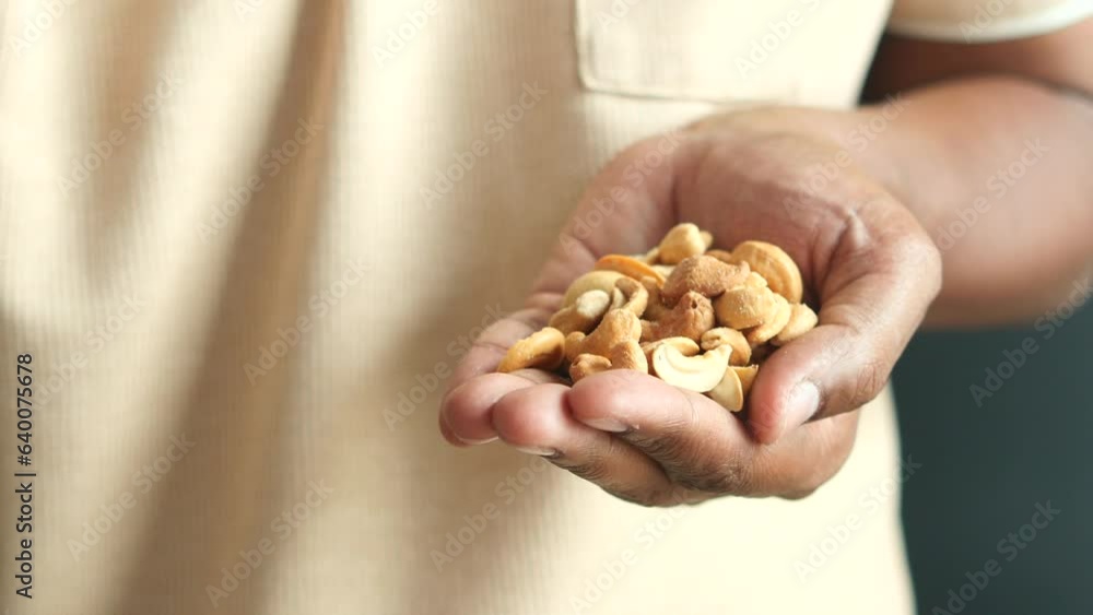 Poster young men hand pick cashew nuts 