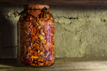 A jar of dried fruit on the shelf. Home preservation for the winter. Dried apples in a glass jar.