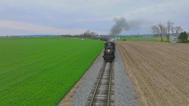 Head on Drone View of an Antique Steam Passenger Train Approaching While Traveling Thru Farmlands