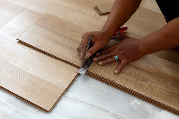 worker joining vinyl floor covering at home renovation