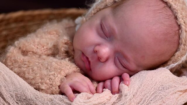 Sleeping newborn beautiful cute baby girl or boy before photo session during first week of life. 4k slow motion raw video. Happy Family concept. Small baby at wicker basket sleep in warm lamb costume