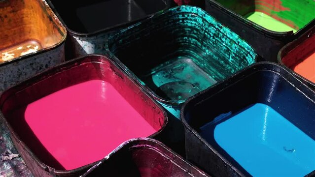 Traditional fabric dye in a variety of colours in plastic containers ready for use