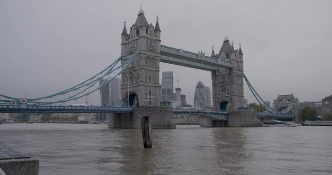 Boat rides under the famous Tower Bridge in London on a rainy day, static shot