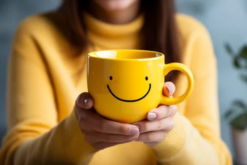 Gordijnen Happy tea drink with happy emoji face on big yellow cup in woman's hands. The most happiest and coffee good vibes motivation. Copy space, empty place for text. Generative AI © Valeriia