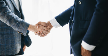 Obraz premium Business partnership handshake concept.Photo two coworkers handshaking process.Successful deal after great meeting. in office..