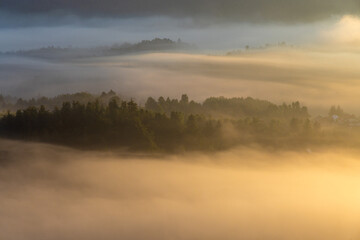 Fototapeta na wymiar Dawn with golden morning mist in a mountain valley, Croatia