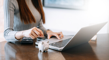 Women are putting coins in a piggy bank for a business that grows for profit and saving money for the future. planning for retirement concept.