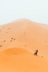 Fototapeta na wymiar Motorbike racing through Sahara Desert, chebbi dune in Merzouga, Morocco