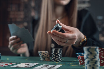 Young caucasian woman playing poker holding casino chips and makes a bet, raises