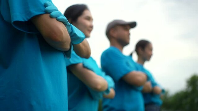 Happy volunteer people group arm crossing in volunteering charity activities cleaning up in park. Corporate social responsibility and society activity for Environment . Ecology and CSR concept.