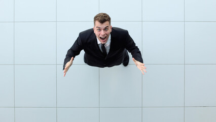 Celebrating success. Low angle view of excited young businessman keeping arms