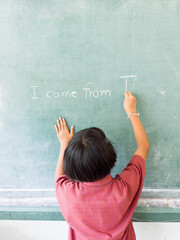 During English class Students write sentences on the blackboard