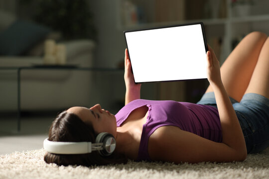Woman with headphone showing blank tablet screen