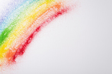 Rainbow sand flag marks LGBT history month. Top view image displays colorful sand art on white, including an open space for inclusive and supportive text