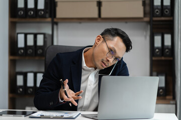 Male businessman talk mobile phones and working on laptop computers, online business, work from home, teleworking concept.