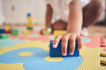 Building blocks, hands and toddler at daycare with development on number carpet and ground. Learning, baby and toy with nursery, motor skills and child game at kindergarten with youth and cube - obrazy, fototapety, plakaty
