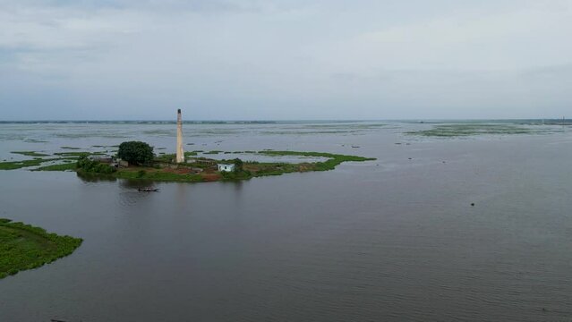Old brick chimney on the bank of the river in Bangladesh. Aerial view of lake, Lighthouse on the Titas River in Bangladesh.