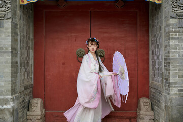 An Oriental beauty in ancient attire holding an umbrella