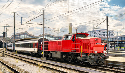 Fototapeta na wymiar Switcher locomotive with passenger wagons at Basel Station in Switzerland