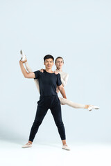 Ballet Concepts. Asian Young Man and Caucasian Woman Performing As Ballet Dancers Over Grey in Studio During Suppots As Classical Dance Aesthetics With Choreography Art © danmorgan12