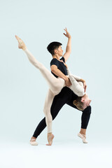 Ballet Concepts. Asian Young Man and Caucasian Woman Performing As Ballet Dancers Over Grey in Studio During Suppots As Classical Dance Aesthetics With Choreography Art © danmorgan12