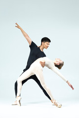 Dance Couple of Asian Young Man and Caucasian Woman Performing As Ballet Dancers Over Grey in Studio During Suppots As Classical Dance With Choreography Aesthetics Art © danmorgan12