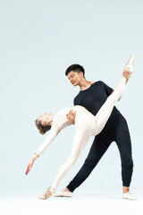 Dance Couple of Young Man and Caucasian Woman Performing As Ballet Dancers Over Grey in Studio During Suppots As Classical Dance With Choreography Elements © danmorgan12
