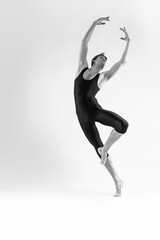 Professional Male Ballet Dancer Young Athletic Man in Black Suit Posing in Ballanced Dance Pose Studio On White.