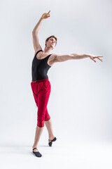 Stretching of Concentrated Contemporary Ballet Dancer Flexible Athletic Man Posing in Red Tights in Ballanced Dance Pose With Hands Lifted
