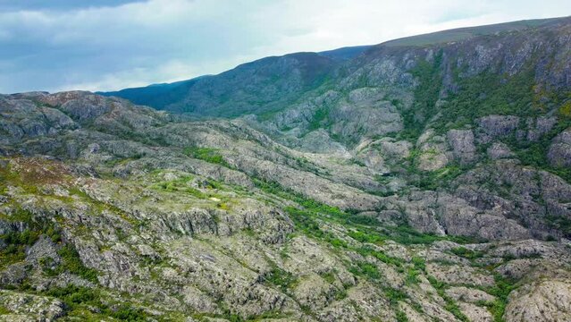 Aerial trucking pan of rio tera canyon, green vegetation cut across exposed rock