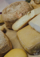 hand made baked stuffed rolls and pieces of cheese. Delicious pastries on wooden cutting board and parchment paper at the street food fair. Soft focus blurred and noise effect