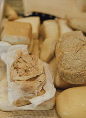 hand made baked stuffed rolls and pieces of cheese. Delicious pastries on wooden cutting board and parchment paper at the street food fair. Soft focus blurred and noise effect