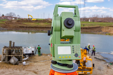 Total station in front of Mobile crane and drilling machine working together on bridge foundation
