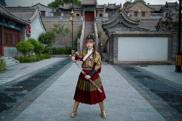 An Oriental beauty dressed in ancient warrior attire, wielding a weapon