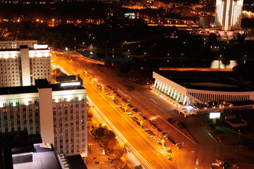 Top view of the night city, lights of lamps and cars in the dark