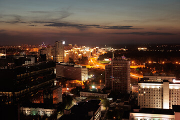 Top view of the night city, lights of lamps and cars in the dark