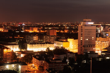 Top view of the night city, lights of lamps and cars in the dark