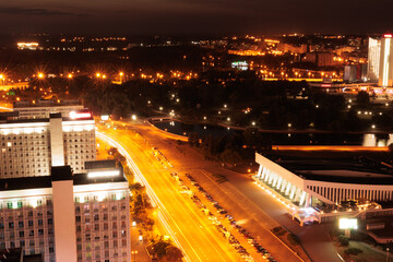 Top view of the night city, lights of lamps and cars in the dark