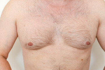 Close up of hairy man's chest, male nipples, light thin hair on breast unrecognisable young guy....