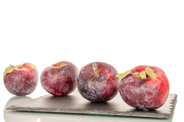 Four sweet organic red apples on slate stone, macro, isolated on white background.