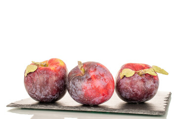 Three sweet organic red apples on slate stone, macro, isolated on white background.