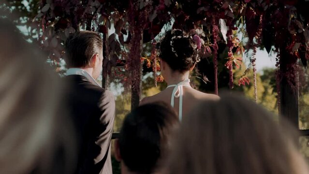 Slow motion shot of a newly married husband and wife standing at the alter