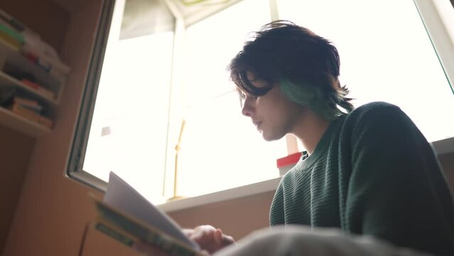 smart girl sitting and reading a book in her room. modern business concept of training and development. the student reads a book and spends her free time in the room. lifestyle self-development