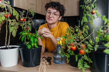 View of a young woman tending to her plants and vegetables in her own kitchen in the garden - environment and ecology theme