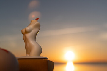 Candles female silhouette against sunset background