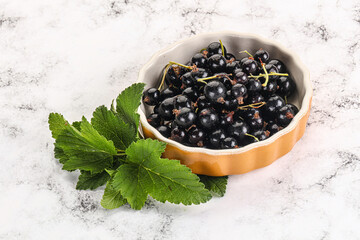 Juicy black currant berries in the bowl