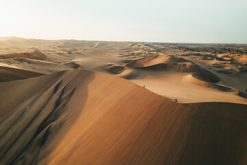 Person on sand dune in desert sunset of Huacachina, Ica, Peru, South America