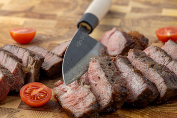 A steak on a cutting board with herbs and spices.Grilled beef tenderloin steak on a wooden board with grilled vegetables. Filet Mignon recipe concept, selective focus