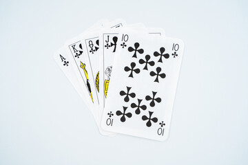 Royal straight flush playing cards poker hand in clubs isolated on white background.
