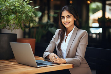 Young indian businesswoman or corporate employee using laptop